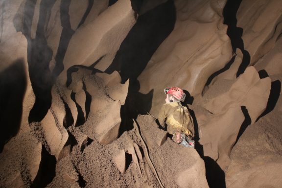 Alex beim Hochklettern der mit Lehm verschmierten  Wand